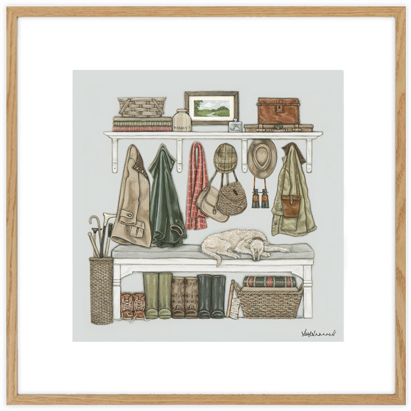 A framed art print depicting a cozy, rustic boot room shelf scene with coats, hats, boots, baskets, and a sleeping dog, presented in a light wood frame with a white mount.