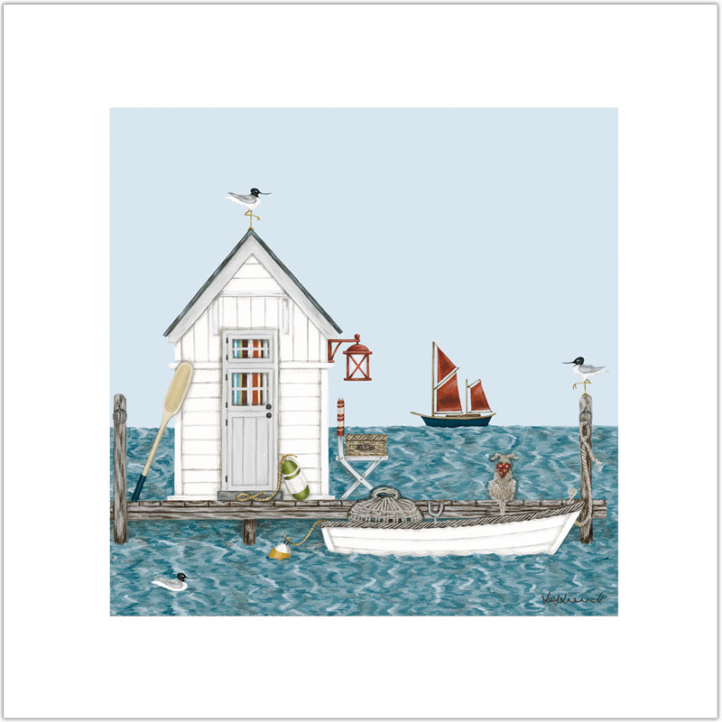 A giclee print featuring a little white clapboard fishing hut on a jetty with a dingy containing a lobster pot, moored up alongside. There is a dog sitting on the jetty, and sea gulls sat on the posts. There is a scooner in the background.