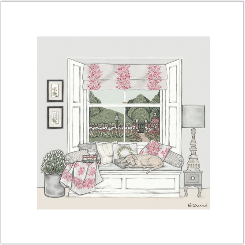 Giclee print of a window seat set in a bay sash window, topped with cushions, and a sleeping dog. Pictures on the wall, a large flower arrangement, side table, lamp, books and cup of tea in the room. The window overlooks countryside, a walled garden containing alliums and a dovecote.