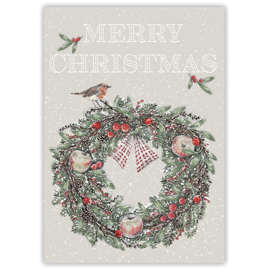 A Christmas greeting card with a snowy off-white background, featuring the words “MERRY CHRISTMAS” above a decorated wreath with red berries, pinecones, ornaments, holly leaves, and a robin perched on top.