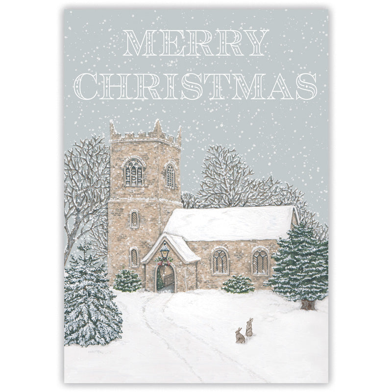 A Christmas card featuring an illustration of a snow-covered stone church in a winter landscape, with a couple of rabbits, falling snow and the words “MERRY CHRISTMAS” at the top.
