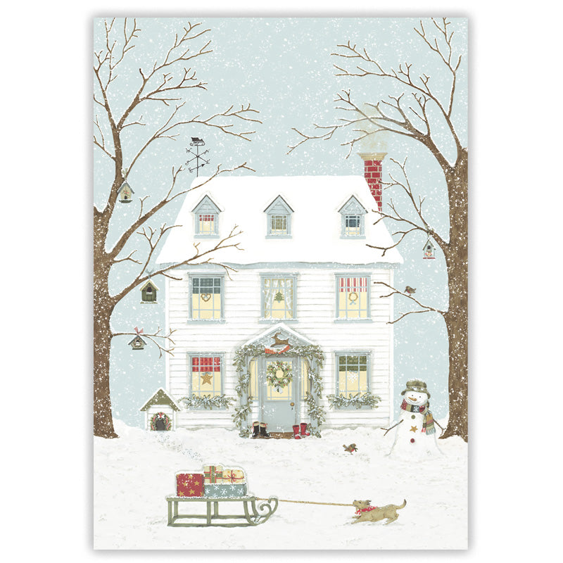 A winter holiday illustration of a snow-covered white house with bare trees, a snowman, a sled with wrapped gifts, and a dog in the foreground under a pale blue snowy sky.