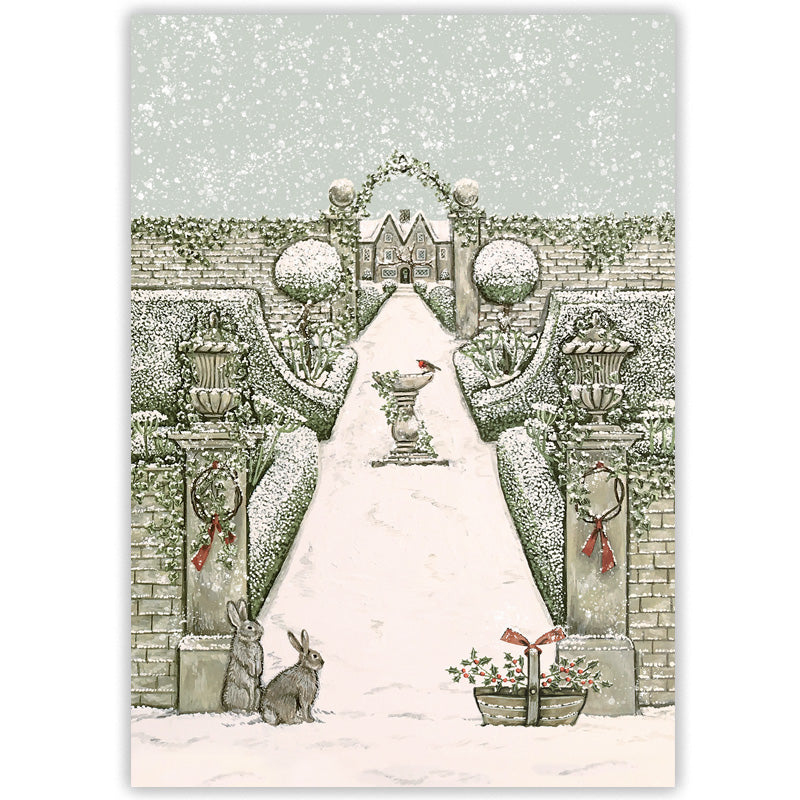 A winter garden illustrated Christmas card with a snow-covered path leading through an archway to a distant house, with hedges, urns, rabbits, and falling snow. 
