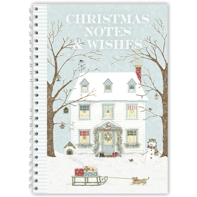 A spiral-bound notebook titled 'CHRISTMAS NOTES & WISHES' with a winter illustration of a snow-covered house, bare trees, gifts, a sled, and a dog on the cover, shown against a plain white background.