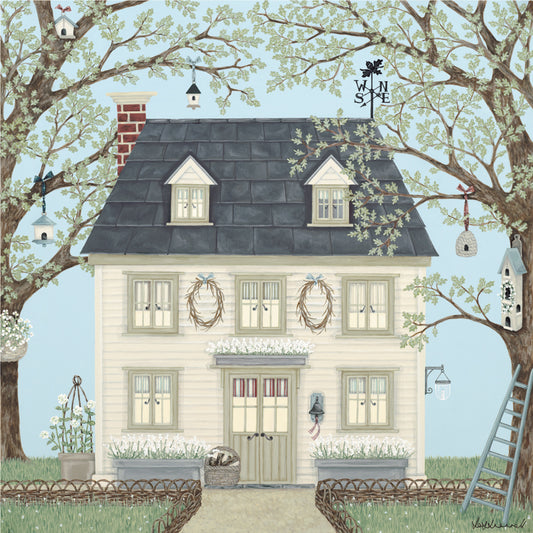 A cream coloured clapboard New England style house with a slate roof and weather vane. Flanked by oak trees.