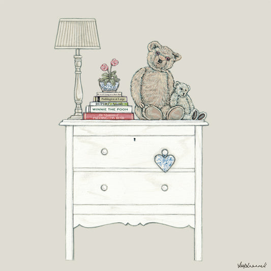 A giclee print featuring 2 old bears , Edward and Bertie, sat on a chest of drawers next to a pile of books, all about bears, and a lamp.
