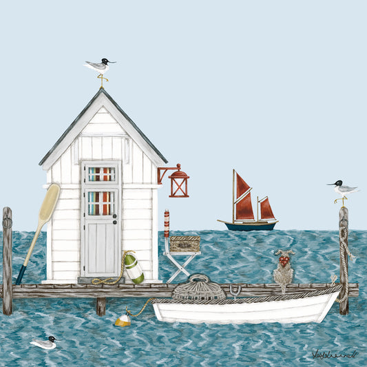 A giclee print featuring a little white clapboard fishing hut on a jetty with a dingy containing a lobster pot, moored up alongside. There is a dog sitting on the jetty, and sea gulls sat on the posts. There is a scooner in the background.