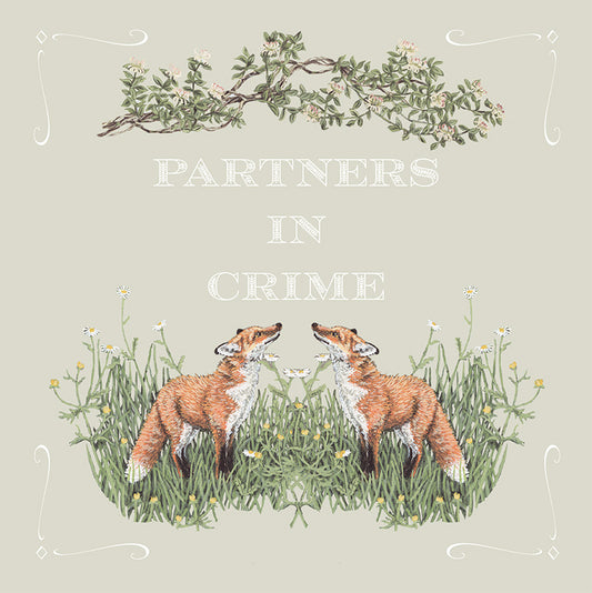 An illustrated greetings card despicting two foxes standing in grass with the text 'Partners in Crime' above them on a light background.