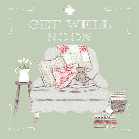 A pretty illustrated get well soon card, depicting a comfortable arm chair containing a teddy bear, and books and a cup of tea to one side.